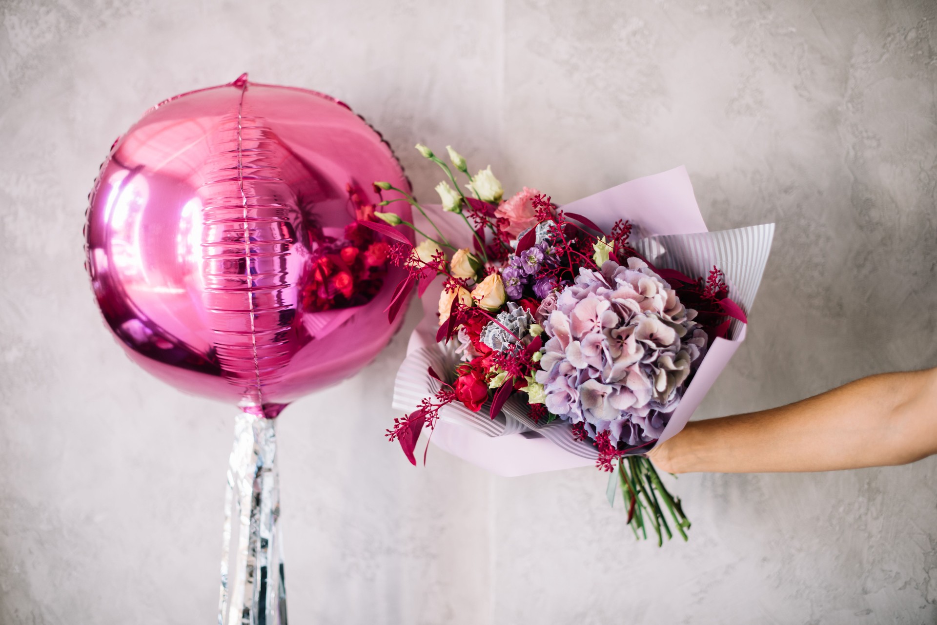 Ocean City maryland blossoming bouquet of fresh flowers hydrangea, eustoma, matthiolacarnations, roses, eucalyptus in pink and purple colors with magenta inflated balloons