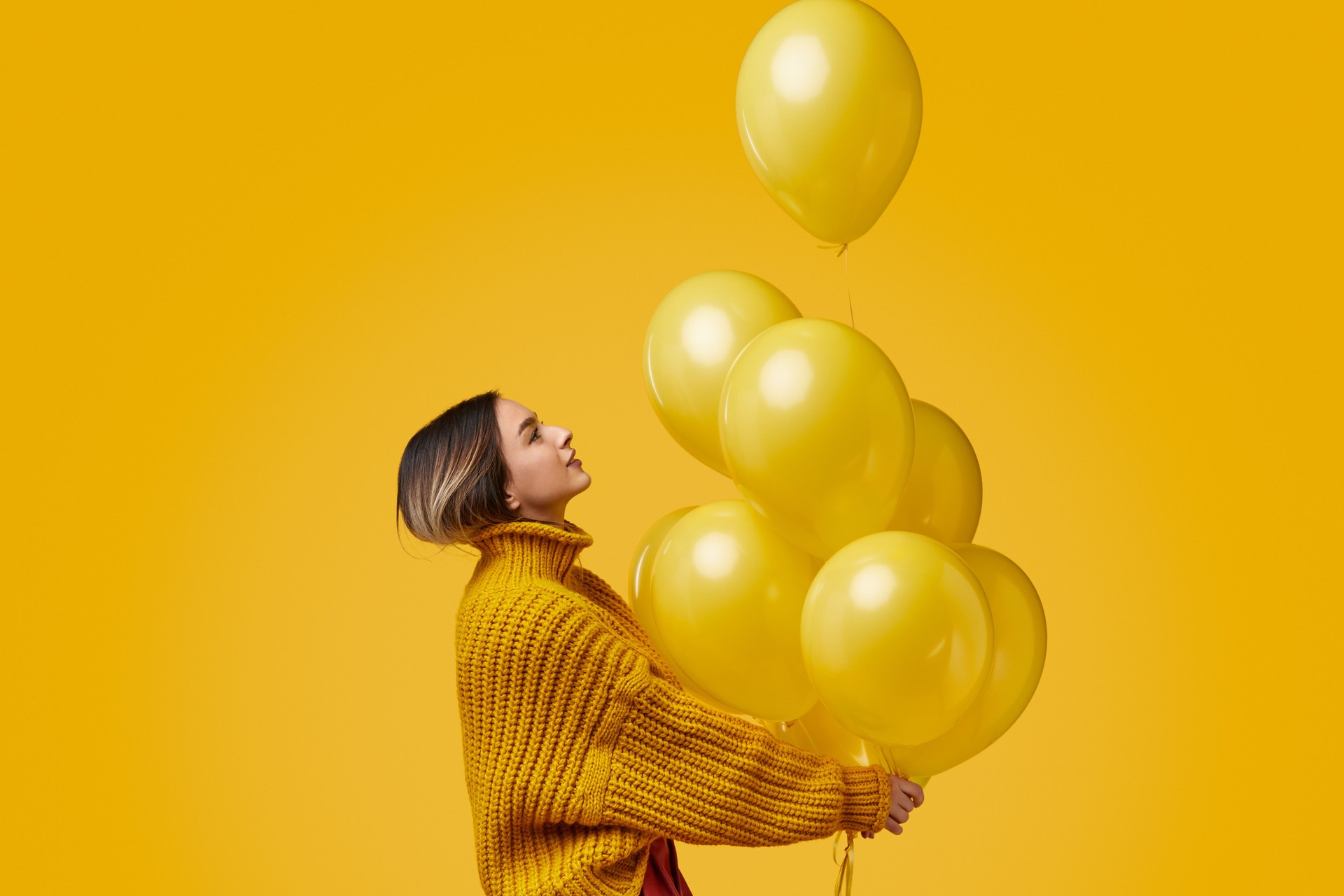 Young woman releasing balloons