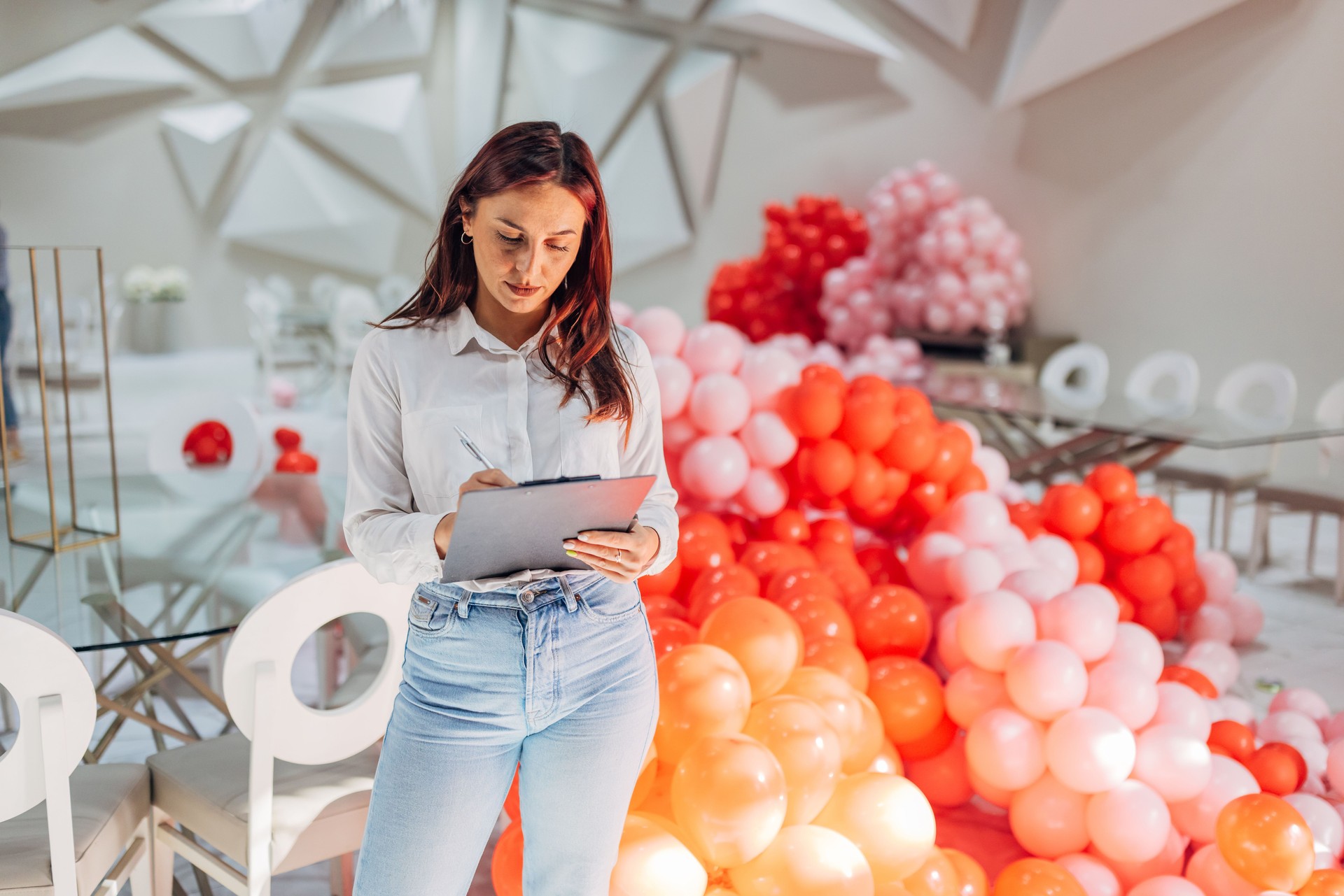 A female party organizer crosses tasks off her to-do list while decorating a restaurant for a party